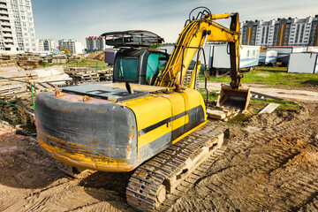 A powerful crawler excavator is working on a construction site. Close-up. Preparation of a pit for construction. Excavation.