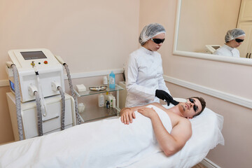 Young man receiving epilation in beauty center. laser hair removal procedure