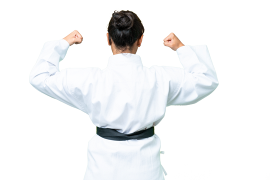 Young Uruguayan woman over isolated chroma key background doing karate in back position