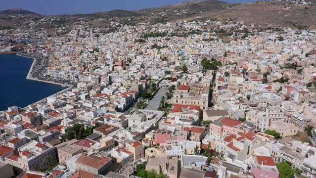 Aerial: Slow panoramic drone shot of Miaouli square in Ermoupoli of Syros island, Greece on a sunny day
