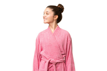 Teenager girl in a bathrobe over isolated chroma key background looking side