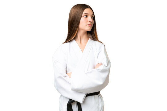 Teenager girl over isolated chroma key background doing karate keeping the arms crossed