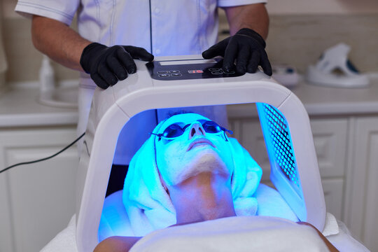Woman getting facial treatment with led therapy.
