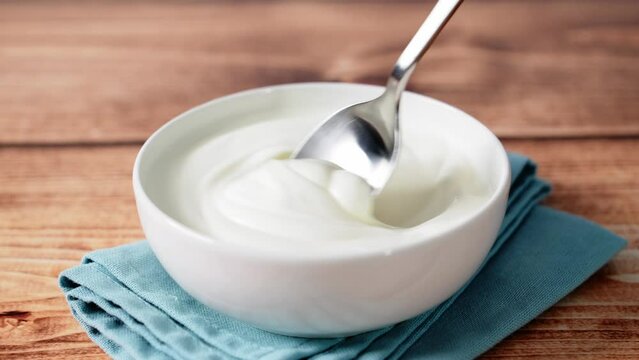 Sour cream or white yogurt or cream cheese or mayonnaise in a bowl on the rustic wooden table. Stock video 4k.