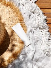 Cosmetic sunscreen product with UVA and UVB protection in white plastic tube. Summer atmosphere. Presentation stage for cosmetic product advertising. Healthy skincare concept.
