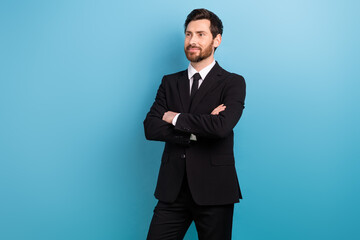 Obraz na płótnie Canvas Photo of thoughtful confident entrepreneur guy dressed black suit arms folded looking empty space isolated blue color background