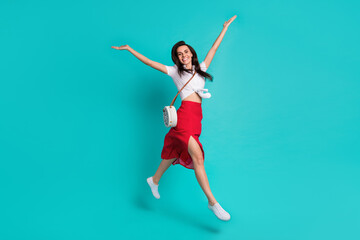 Fototapeta na wymiar Photo of charming shiny lady dressed white crop top jumping high having fun isolated turquoise color background