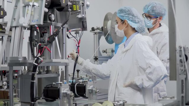 group of caucasian worker man and woman in ppe suit walking to discussion or talking to inspecting quality control surgical face mask in production line at industry factory.