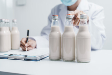 Quality control laboratory dairy factory professional people checking milk bottles quality, Dairy factory industry products.