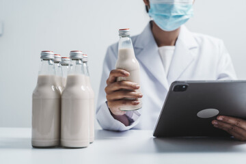 Quality control laboratory dairy factory professional people checking milk bottles quality, Dairy...