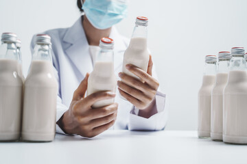 Quality control laboratory dairy factory professional people checking milk bottles quality, Dairy...