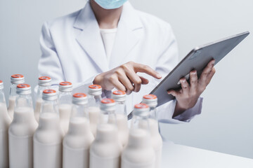 Fototapeta premium Quality control laboratory dairy factory professional people checking milk bottles quality, Dairy factory industry products.