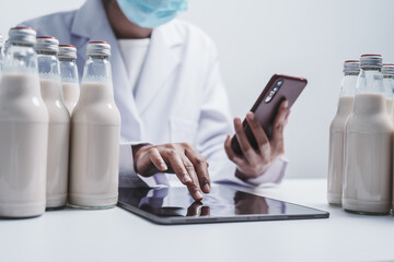 Quality control laboratory dairy factory professional people checking milk bottles quality, Dairy factory industry products.