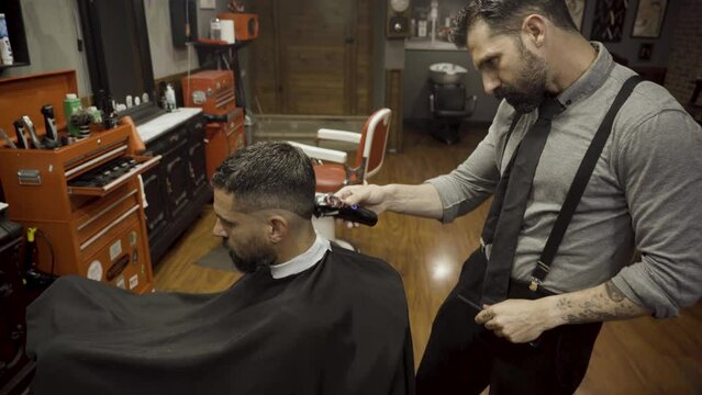 Barber Making A Haircut To His Client Using Cutting Machine - close up