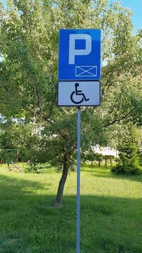 Parking only for disabled drivers. Road sign against against backdrop of green lawn. Concept of Accessible Parking and locations. Adapted spaces for people with disabilities. Inclusion.