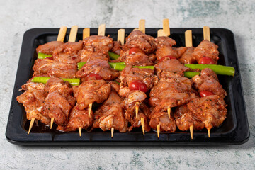 Chicken skewer. Chicken skewers with raw sauce on gray background