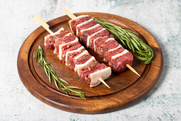 Beef skewer. Shish kebab prepared with raw ribeye and minced meat on a gray background