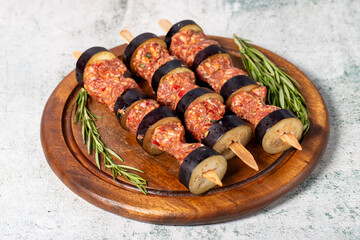 Eggplant kebab. Eggplant shish kebab with raw minced meat on a gray background. Turkish cuisine delicacies. Local name patlican kebabi