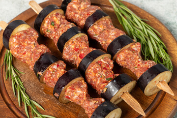 Eggplant kebab. Eggplant shish kebab with raw minced meat on a gray background. Turkish cuisine...