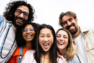 Obraz premium Diverse group of friends taking a selfie in the street. Cheerful multiracial group of young hipsters taking a picture outside and looking at camera.