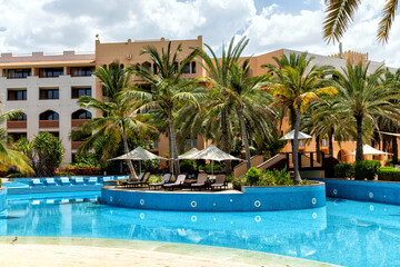 Swimming pool with clear water surrounded by palm trees in one of the best resorts