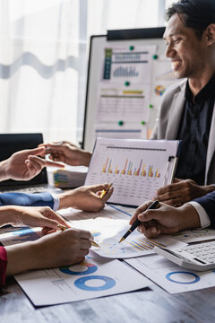 Businessman discussing work on paper SEO data graph chart on laptop Asian man and woman share career idea about project budget report in meeting in office