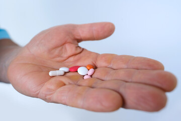 nurse, doctor, patient holds drugs in hand, hand stretches on palm pills, capsules, vitamins, drugs in male palm on light background, ensuring delivery of proper medication and healthcare support