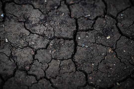 Full frame overhead view of cracked dry black earth