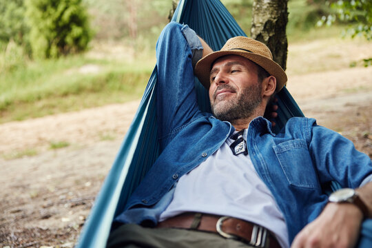 Happy adult man relaxing in hammock