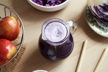 A jug of fresh purple cabbage juice on a table