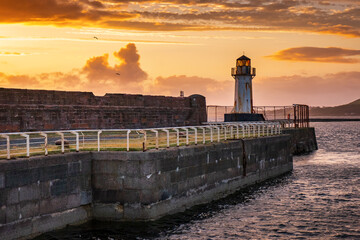 Ardrossan harbour wall and lighthouse at sunset, North Ayrshire, Scotland.