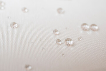 Clear water drops on white canvas