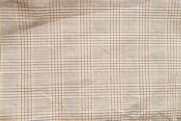 Checkered pattern on beige fabric, close up of textile texture