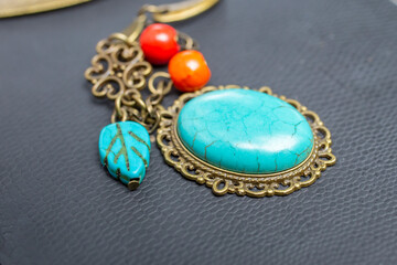 turquoise stone brooch  on black texture, soft focus