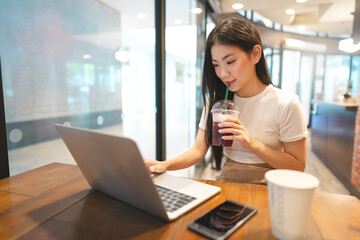 Happy business freelance asian woman holding coffee cup at cafe urban lifestyle