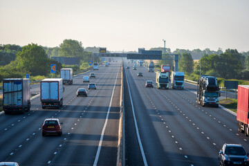 heavy traffic moving at speed on uk motorway in england at sunrise