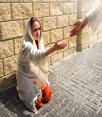 A girl in poor clothes sits on the ground