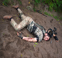 A wounded soldier lies on the ground