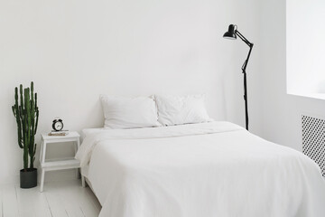 Minimalistic totally white bedroom. Clear white light flat in scandinavian style. Copy space. Minimal design. interior, comfort and bedding concept - bed at home