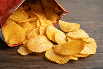 Potato chips, delicious BBQ seasoning spicy for crips, thin slice deep fried snack fast food in open bag.