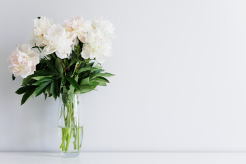 Beautiful fresh white peonies bouquet in vase on the table