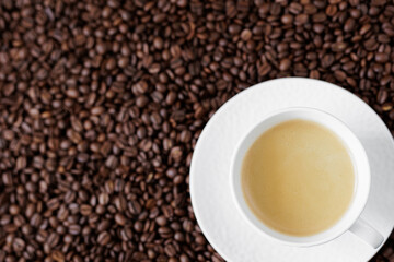 Top view of espresso with coffee foam in a cup on a dark background from coffee beans with copyspace