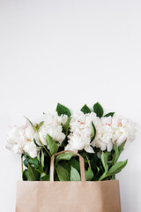 Beautiful white peonies in brown paper bag with copyspace