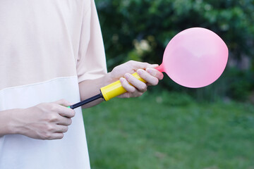 Blowing pink balloon by hand air pump, inflates  air to balloon Concept, children play, toy and...
