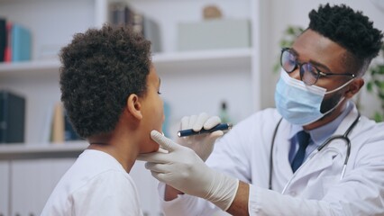 Attentive doctor examining boy's throat, disease symptoms, visit to pediatrician