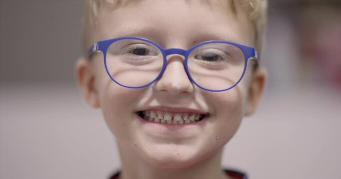 Video portrait of happy young boy with chicken pox wearing glasses and smiling. Looking at camera.