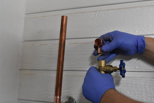 Gloved Hands Test Fitting Valve For Water Heater Supply Line 