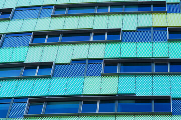Closeup of a facade of a green and blue modern office building in Arnhem in the Netherlands