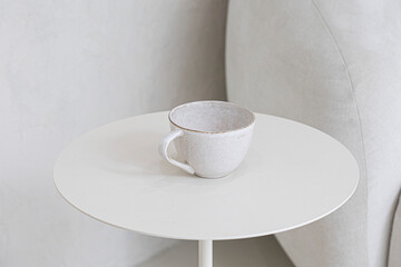 Single empty white ivory teacup on table