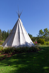 Traditional white tipi seen during a sunny summer day in garden © Anne Richard